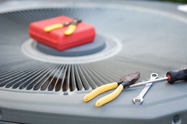 tools resting on top of air conditioning unit